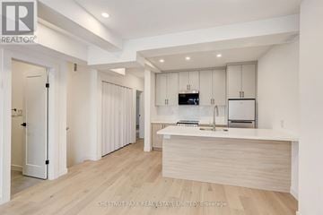 Toronto (Annex) multi-family for rent - A modern kitchen with white cabinets and a wooden island.