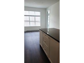 Surrey apartment for rent - A kitchen with white cabinets and a black countertop.