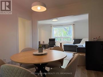 Niagara Falls (Downtown) apartment for rent - A well-lit living room with a dining table and chairs.