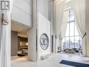 Toronto (Mimico) condo for rent - A large, modern living room with a Chanel logo on the wall.
