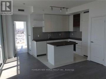 Toronto (Mimico) condo for rent - A kitchen with white cabinets and a black countertop.