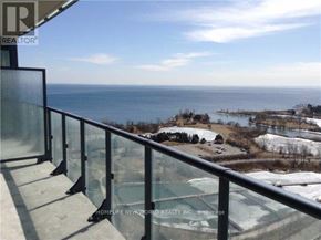 Toronto (Mimico) condo for rent - A balcony with a glass railing overlooks a body of water.