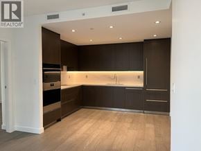 North Vancouver apartment for rent - A modern kitchen with dark brown cabinets and a wooden floor.