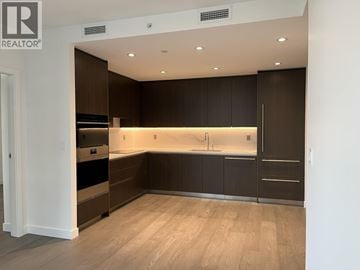 North Vancouver apartment for rent - A modern kitchen with dark brown cabinets and a wooden floor.