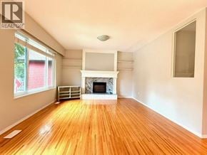 North Vancouver apartment for rent - A large empty room with a fireplace and wooden floors.