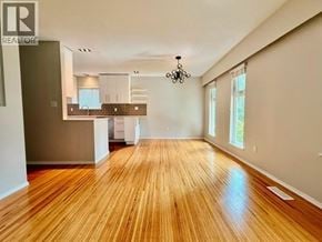 North Vancouver apartment for rent - A large open room with wooden floors and a kitchen area in the background.