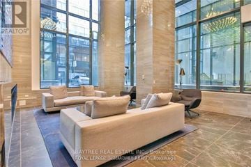 Toronto (Waterfront Communities) condo for rent - A living room with a large couch and a chandelier.