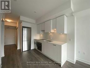 Toronto (Mount Pleasant West) condo for rent - A kitchen with white cabinets and a stainless steel refrigerator.