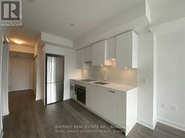 Toronto (Mount Pleasant West) condo for rent - A kitchen with white cabinets and a stainless steel refrigerator.