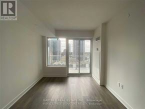 Toronto (Mount Pleasant West) condo for rent - A room with a view of a cityscape through a large window.