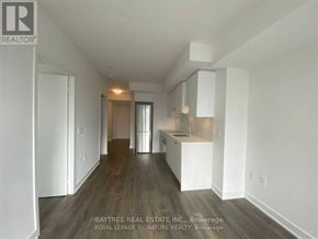 Toronto (Mount Pleasant West) condo for rent - A real estate company logo is displayed on a wall in a spacious, empty room.
