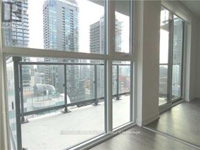 Toronto (Waterfront Communities) condo for rent - A room with a view of a cityscape through large windows.