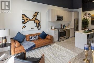 Newmarket (Central Newmarket) condo for rent - A living room with a brown couch and a painting on the wall.