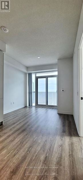 Vaughan (Vaughan Corporate Centre) condo for rent - A spacious room with wooden flooring and a large window.
