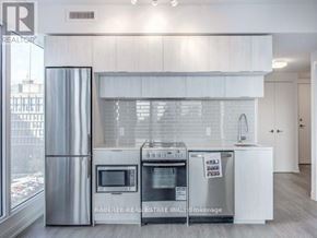 Toronto (Moss Park) condo for rent - A modern kitchen with white cabinets and stainless steel appliances.