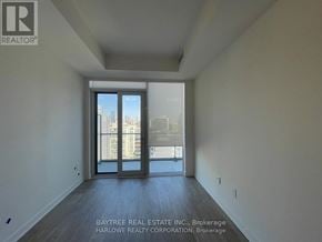 Toronto (Waterfront Communities) condo for rent - A spacious room with a view of the city through the sliding glass doors.