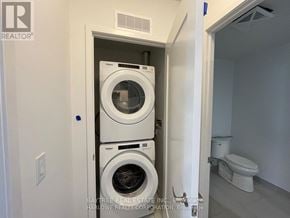 Toronto (Waterfront Communities) condo for rent - A small laundry room with a washer and dryer stacked on top of each other.