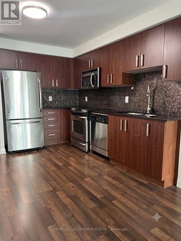 Toronto (Willowdale East) condo for rent - A kitchen with wooden cabinets and a black countertop.