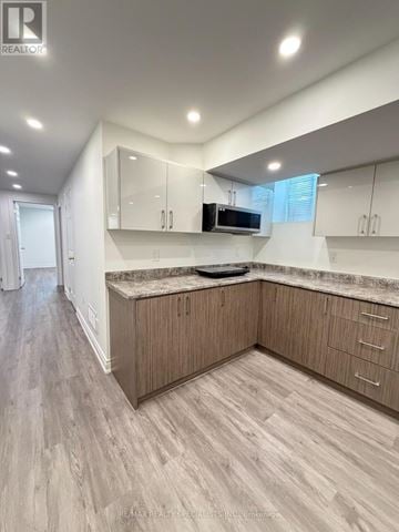 Mississauga (Churchill Meadows) apartment for rent - A modern kitchen with wooden cabinets and a marble countertop.