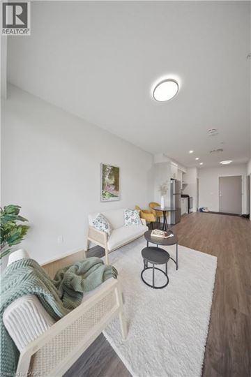 Kitchener apartment for rent - A living room with a white couch and a grey ottoman.
