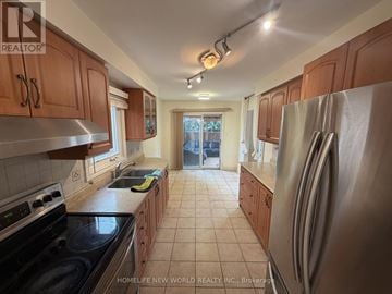 Vaughan (Crestwood-Springfarm-Yorkhill) apartment for rent - A kitchen with wooden cabinets and a stainless steel refrigerator.