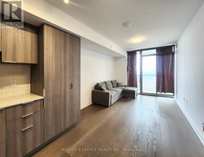 Toronto (Bay Street Corridor) condo for rent - A spacious living room with wooden floors and furniture.