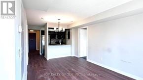 Toronto (Agincourt South-Malvern West) condo for rent - A spacious room with a chandelier and a bar area in the background.