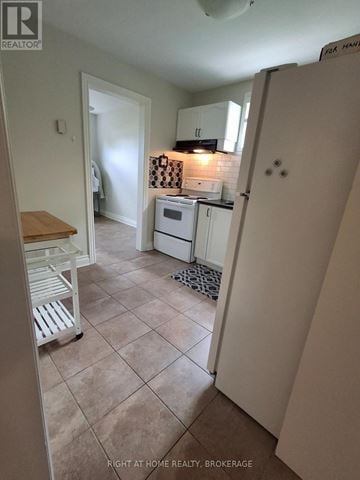 St. Catharines (Port Dalhousie) duplex for rent - A kitchen with a refrigerator, sink, and stove.