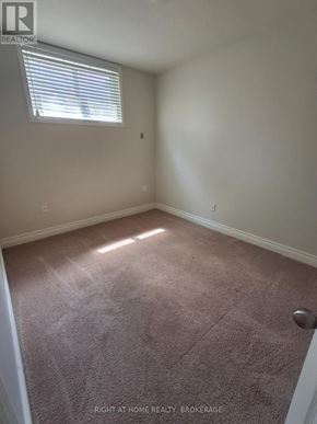 St. Catharines (Port Dalhousie) duplex for rent - A room with a carpeted floor and a window with blinds.