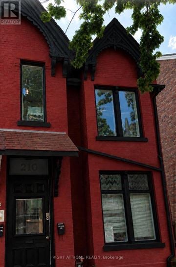 Toronto (University) duplex for rent - A red brick house with a black door and windows.