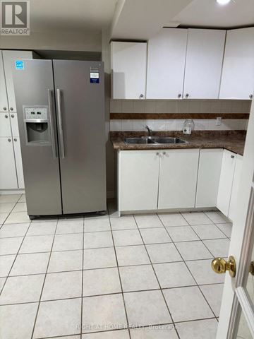 Toronto (West Hill) apartment for rent - A kitchen with a stainless steel refrigerator and white cabinets.