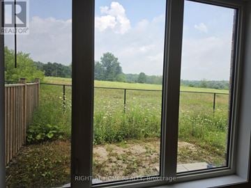 East Gwillimbury (Queensville) townhouse for rent - A window with a view of a field and trees.