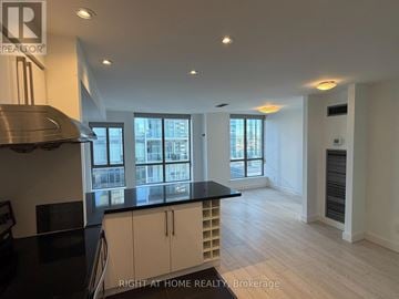 Toronto (Annex) condo for rent - A kitchen with a black counter top and white cabinets.