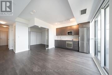 Oshawa (Windfields) condo for rent - A spacious kitchen with a refrigerator, microwave, and oven.