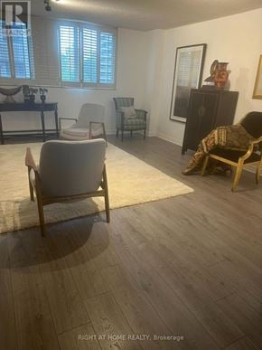 Toronto (Rosedale-Moore Park) condo for rent - A living room with a grey chair and a wooden floor.