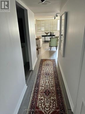 Toronto (Rosedale-Moore Park) condo for rent - A hallway with a rug on the floor and a living room in the background.