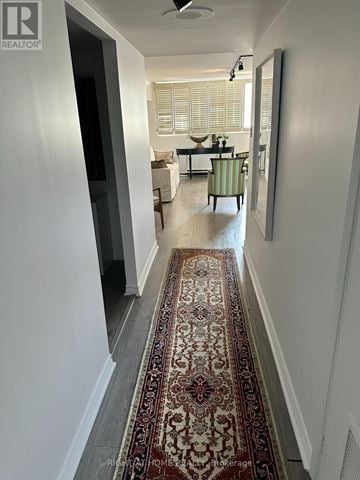 Toronto (Rosedale-Moore Park) condo for rent - A hallway with a rug on the floor and a living room in the background.