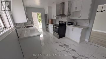 Toronto (Humber Summit) apartment for rent - A kitchen with a black oven and white cabinets.