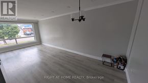 Toronto (Humber Summit) apartment for rent - A room with a large window and a view of a street with cars and trees.