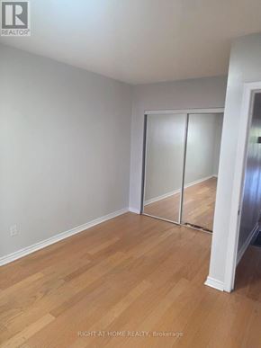 Toronto (Humber Summit) apartment for rent - A room with wooden flooring and a white wall with a sliding door.