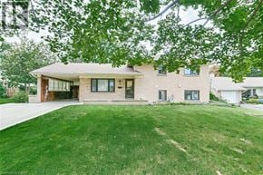 Simcoe apartment for rent - A house with a green lawn and trees in the background.