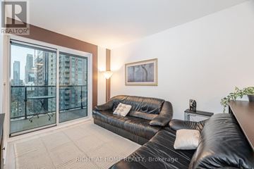 Toronto (Church-Yonge Corridor) condo for rent - A living room with a black leather couch and a framed picture on the wall.