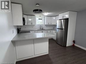 Hamilton apartment for rent - A kitchen with white cabinets and a stainless steel refrigerator.