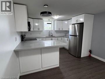 Hamilton apartment for rent - A kitchen with white cabinets and a stainless steel refrigerator.