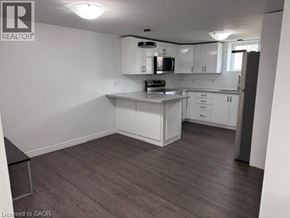 Hamilton apartment for rent - A kitchen with white cabinets and a black countertop.