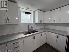 Hamilton apartment for rent - A kitchen with white cabinets and a window above the sink.