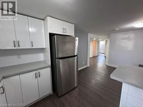 Hamilton apartment for rent - A kitchen with white cabinets and a stainless steel refrigerator.