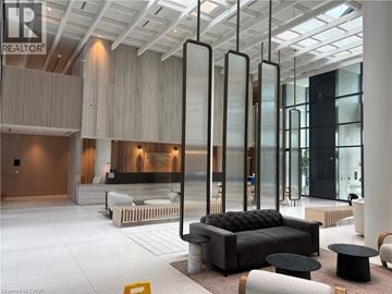 Vaughan condo for rent - A modern living room with a black sofa and a glass partition.