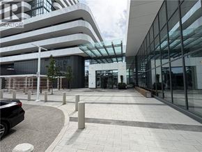 Vaughan condo for rent - A modern building with a glass facade and a car parked in front.