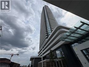 Vaughan condo for rent - A tall building with a curved design stands under a cloudy sky.